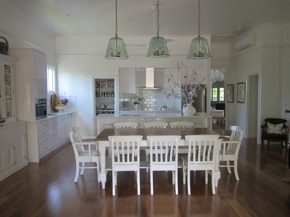 Imagen de comedor de cocina clásico grande con paredes blancas y suelo de madera en tonos medios