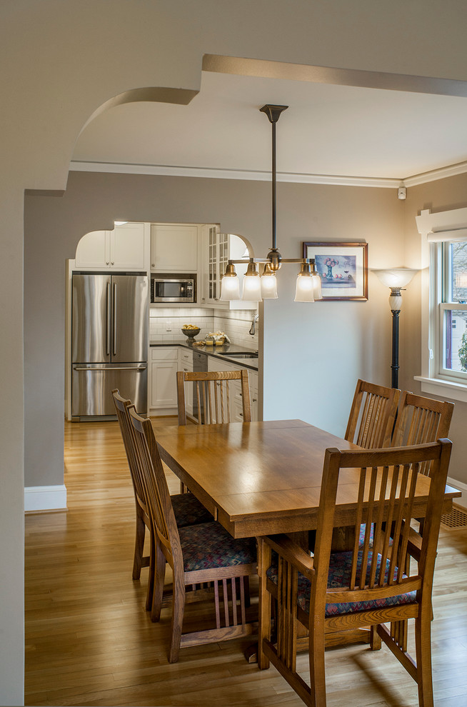Cette photo montre une salle à manger ouverte sur la cuisine craftsman de taille moyenne avec un mur beige et parquet clair.