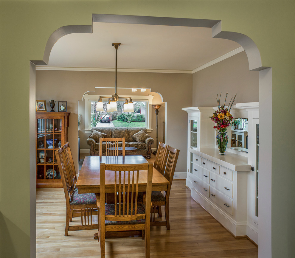 Idées déco pour une salle à manger ouverte sur la cuisine craftsman de taille moyenne avec un mur beige, parquet clair et éclairage.