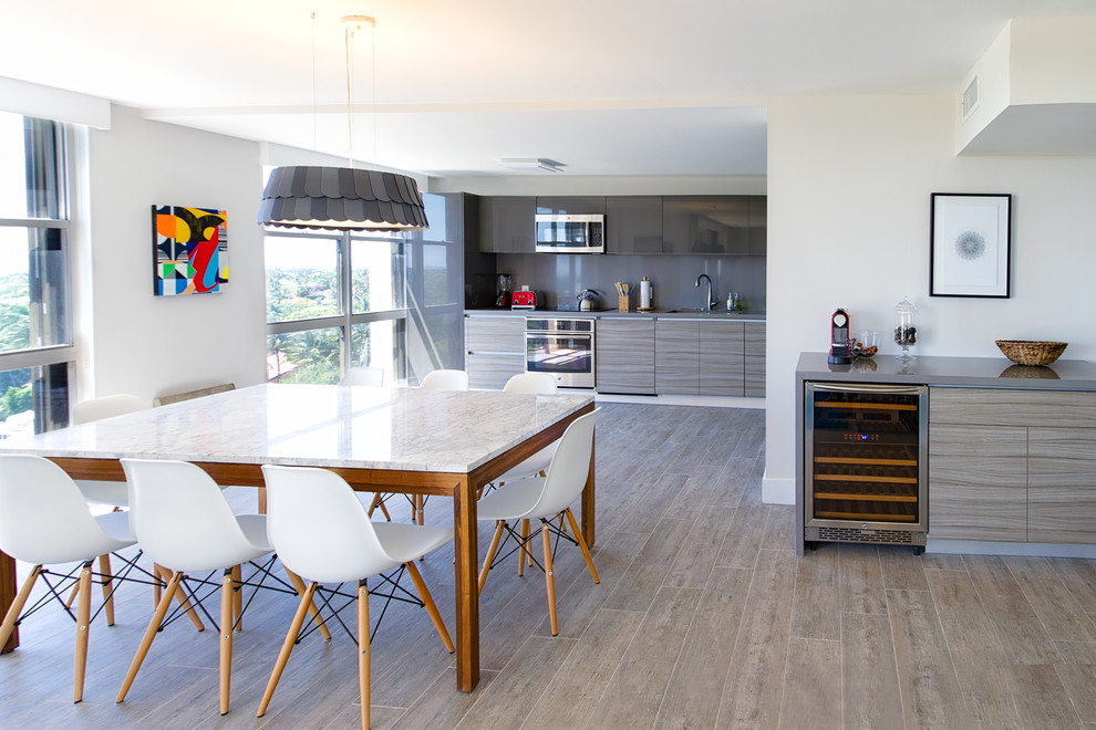 Moderne Wohnküche mit weißer Wandfarbe und braunem Holzboden in Miami