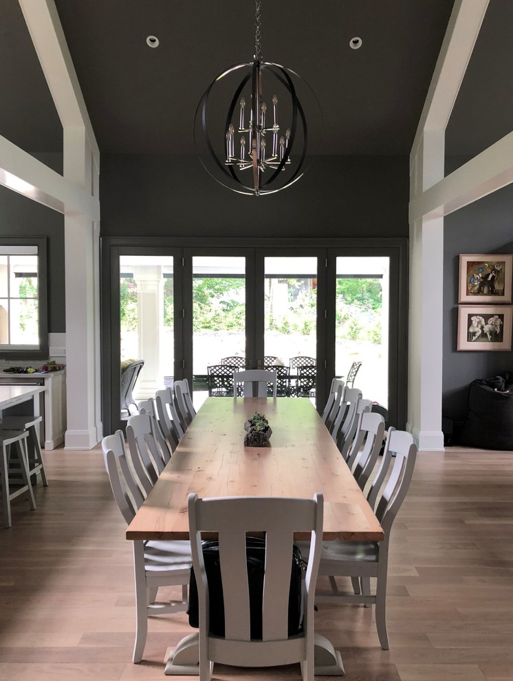 Стильный дизайн: кухня-столовая среднего размера в классическом стиле с серыми стенами, паркетным полом среднего тона, стандартным камином, фасадом камина из дерева и коричневым полом - последний тренд