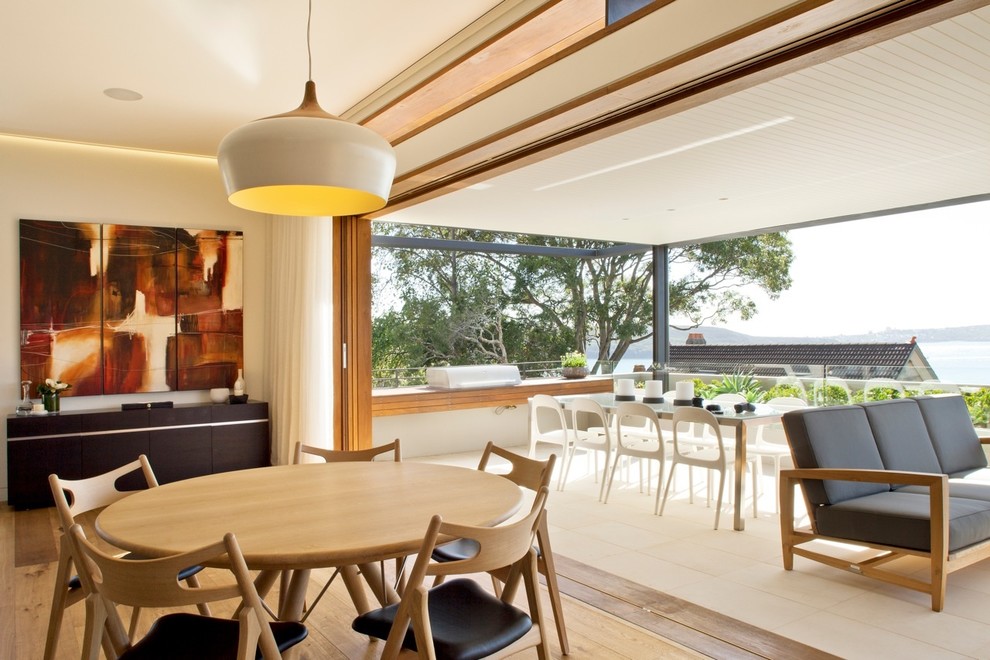 Esempio di una sala da pranzo aperta verso il soggiorno minimalista con parquet chiaro