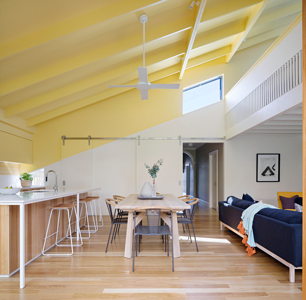 Idee per una sala da pranzo aperta verso il soggiorno design con pareti bianche, pavimento in legno massello medio e pavimento marrone