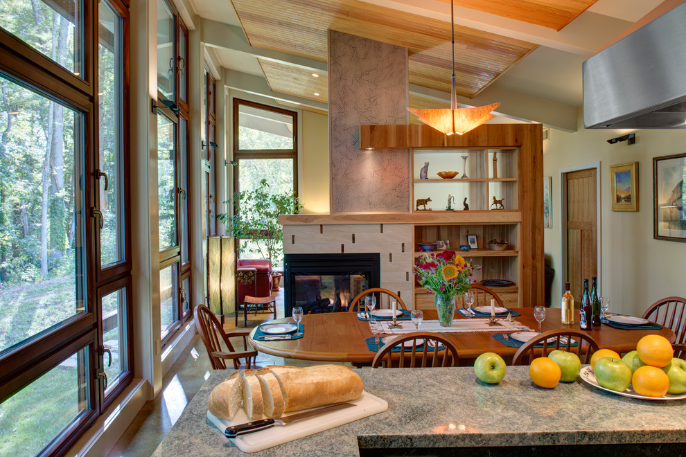 Источник вдохновения для домашнего уюта: кухня-столовая среднего размера в современном стиле с желтыми стенами, бетонным полом, двусторонним камином, фасадом камина из плитки и разноцветным полом