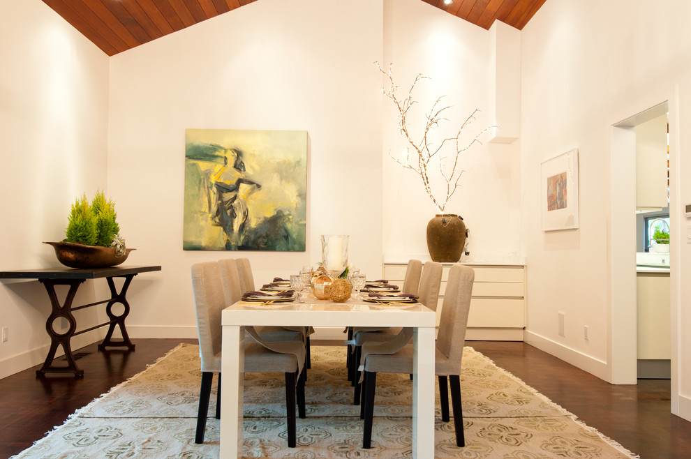 Cette image montre une salle à manger design avec un mur blanc et parquet foncé.
