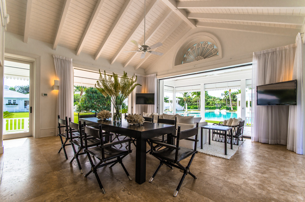 Example of a large island style dining room design in Miami with white walls