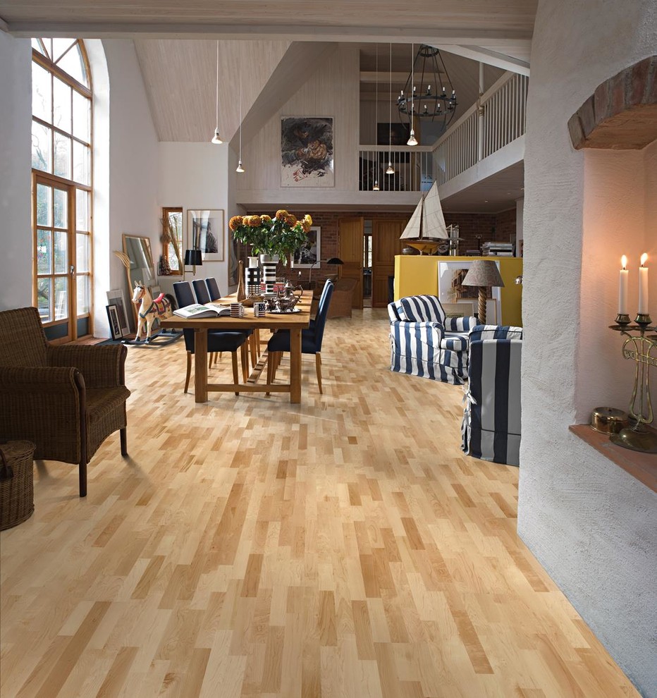 Diseño de comedor actual grande abierto con paredes grises, suelo de madera clara y suelo amarillo