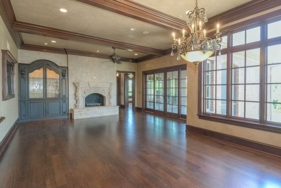 Great room - huge traditional dark wood floor great room idea in Phoenix with beige walls, a standard fireplace and a stone fireplace