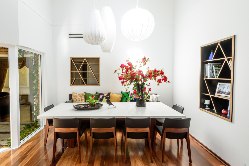 Источник вдохновения для домашнего уюта: столовая в современном стиле с белыми стенами, паркетным полом среднего тона и коричневым полом без камина