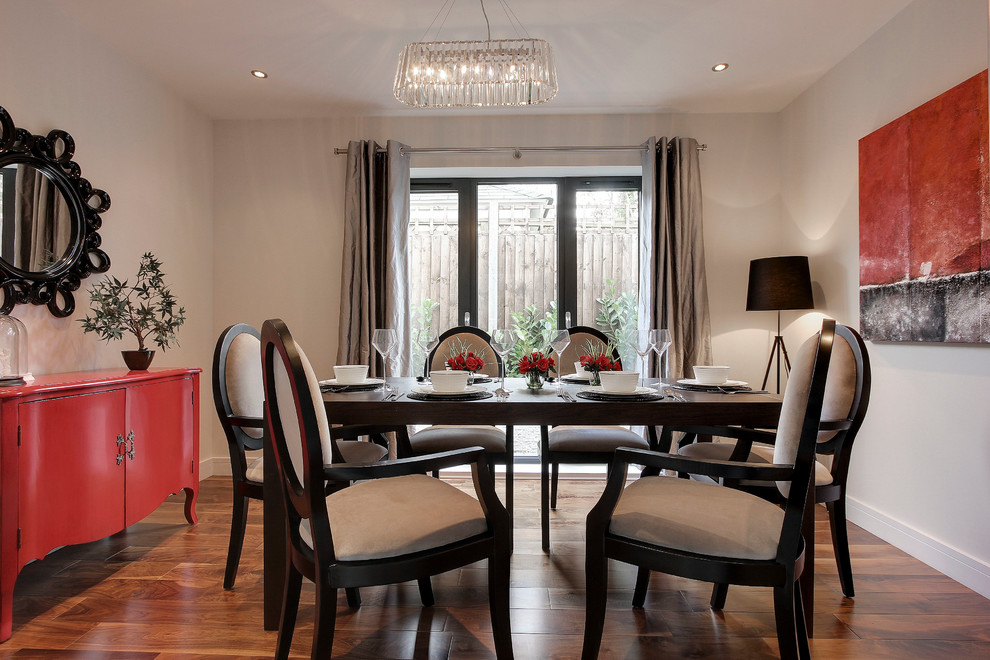 Contemporary enclosed dining room in Hertfordshire with beige walls, medium hardwood flooring and no fireplace.