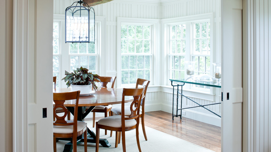 Design ideas for a medium sized coastal enclosed dining room in Boston with white walls and medium hardwood flooring.