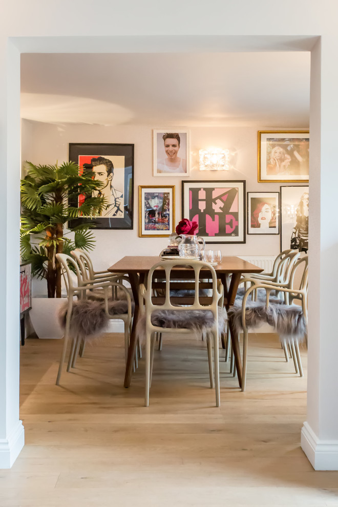 This is an example of a medium sized eclectic enclosed dining room in Berkshire with light hardwood flooring and beige walls.