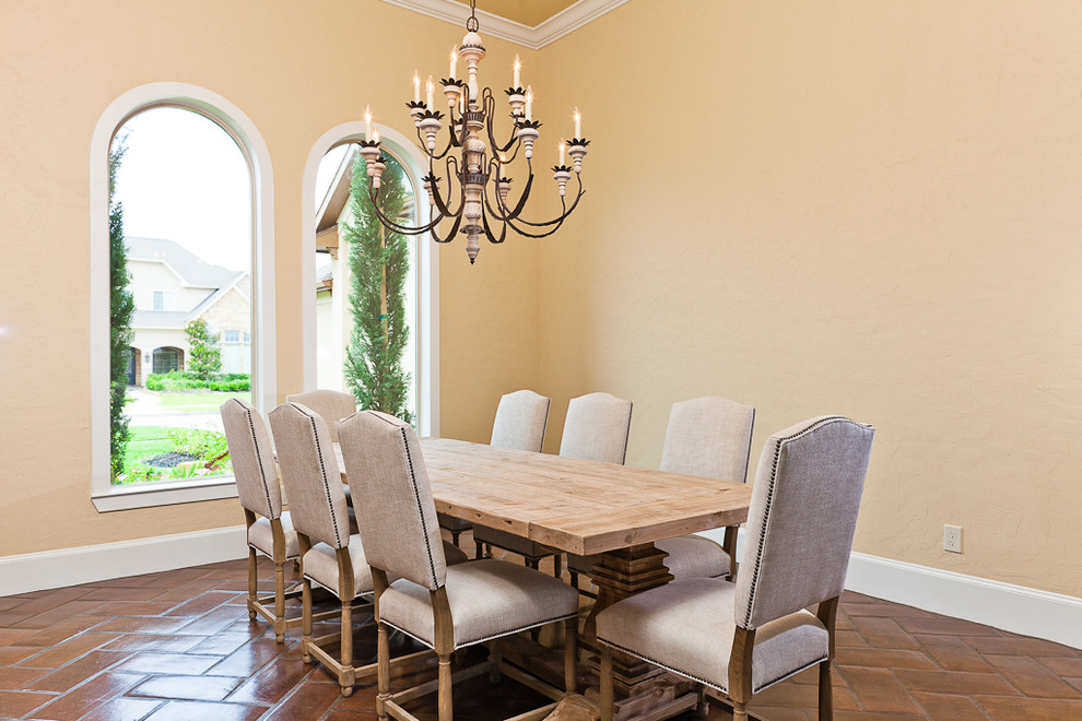 Immagine di una grande sala da pranzo mediterranea chiusa con pareti beige, pavimento in travertino e nessun camino