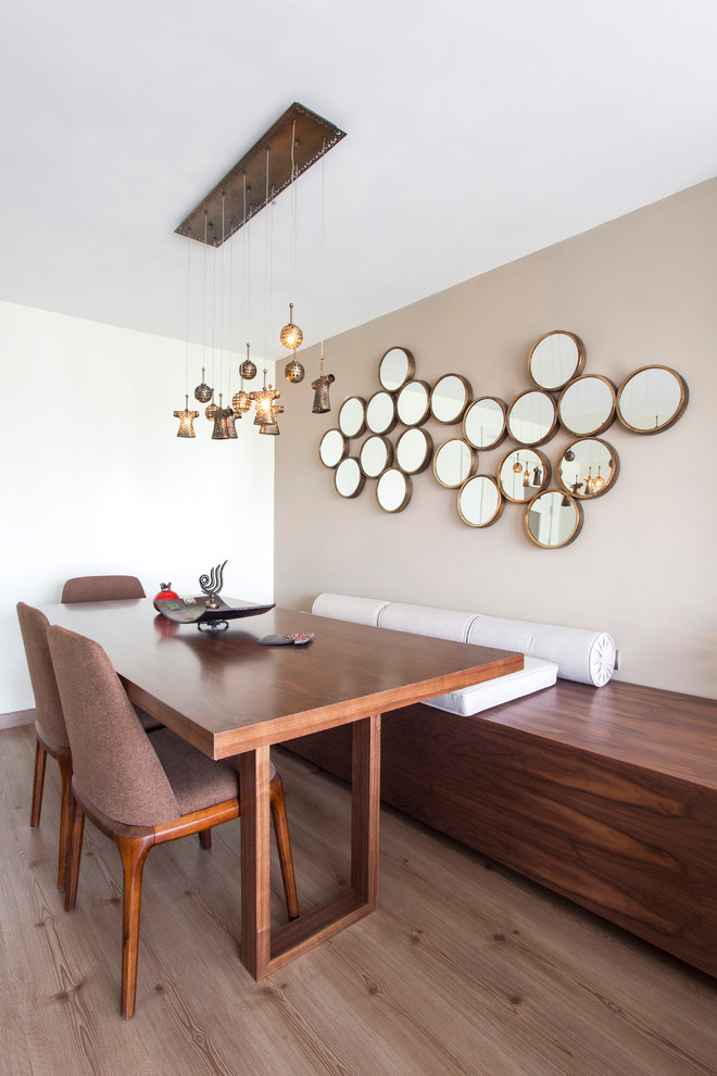 Contemporary dining room in Other with beige walls and dark hardwood flooring.