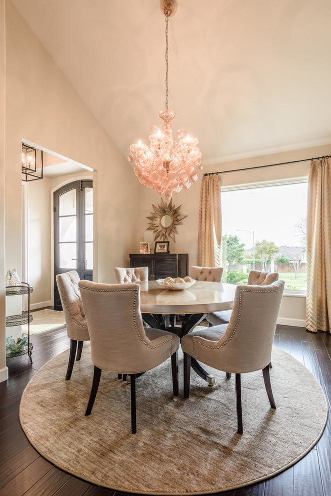 Cette photo montre une salle à manger chic fermée avec un mur beige, sol en stratifié et un sol marron.