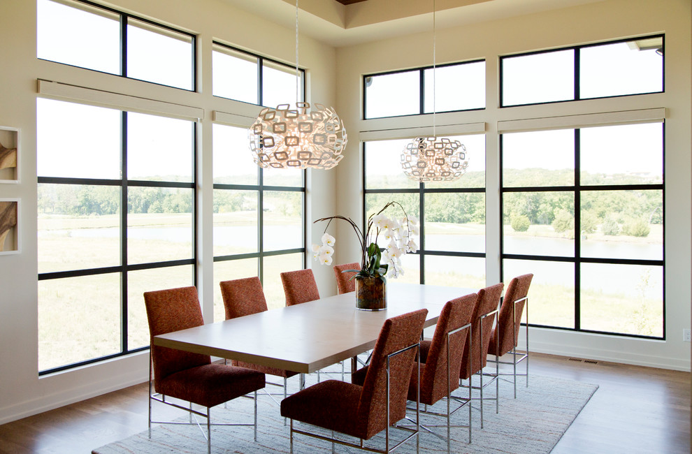 Immagine di una grande sala da pranzo aperta verso la cucina contemporanea con pareti beige, pavimento in legno massello medio e pavimento marrone
