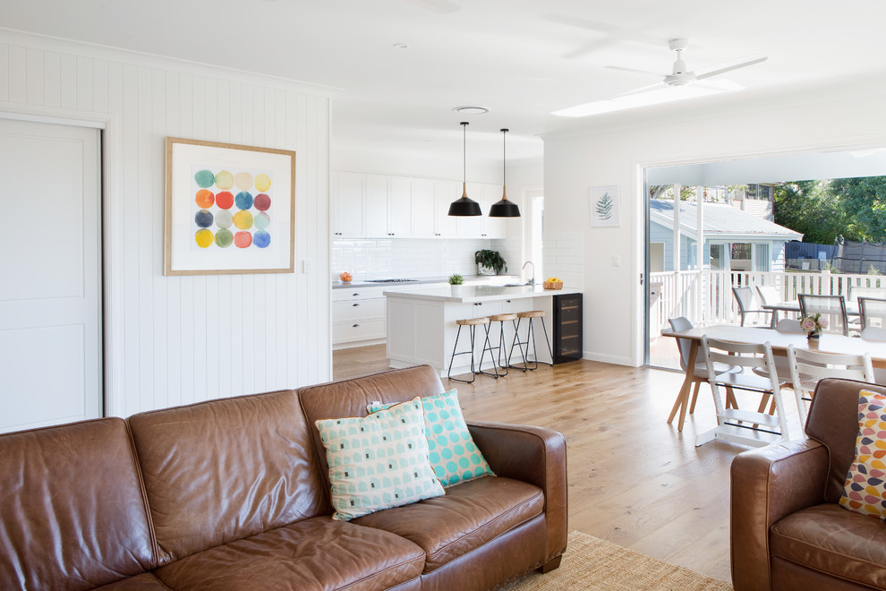 Ispirazione per una sala da pranzo aperta verso il soggiorno design di medie dimensioni con pareti bianche, pavimento in legno massello medio e pavimento bianco