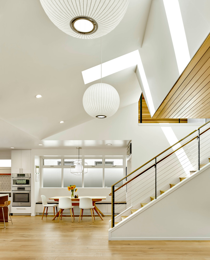 Идея дизайна: большая гостиная-столовая в стиле модернизм с белыми стенами, паркетным полом среднего тона и коричневым полом