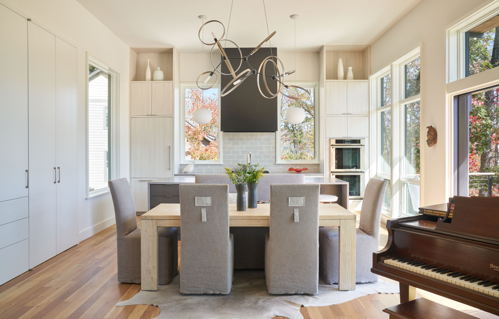 Diseño de comedor de cocina actual grande con paredes blancas, suelo de madera en tonos medios y suelo beige