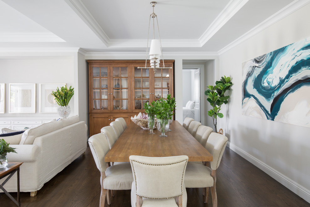 Cette image montre une salle à manger ouverte sur le salon traditionnelle avec un mur gris, parquet foncé, un sol marron et un plafond décaissé.