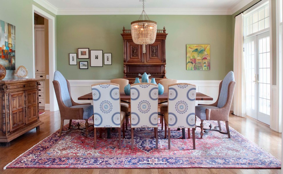 Diseño de comedor clásico con paredes verdes y suelo de madera en tonos medios
