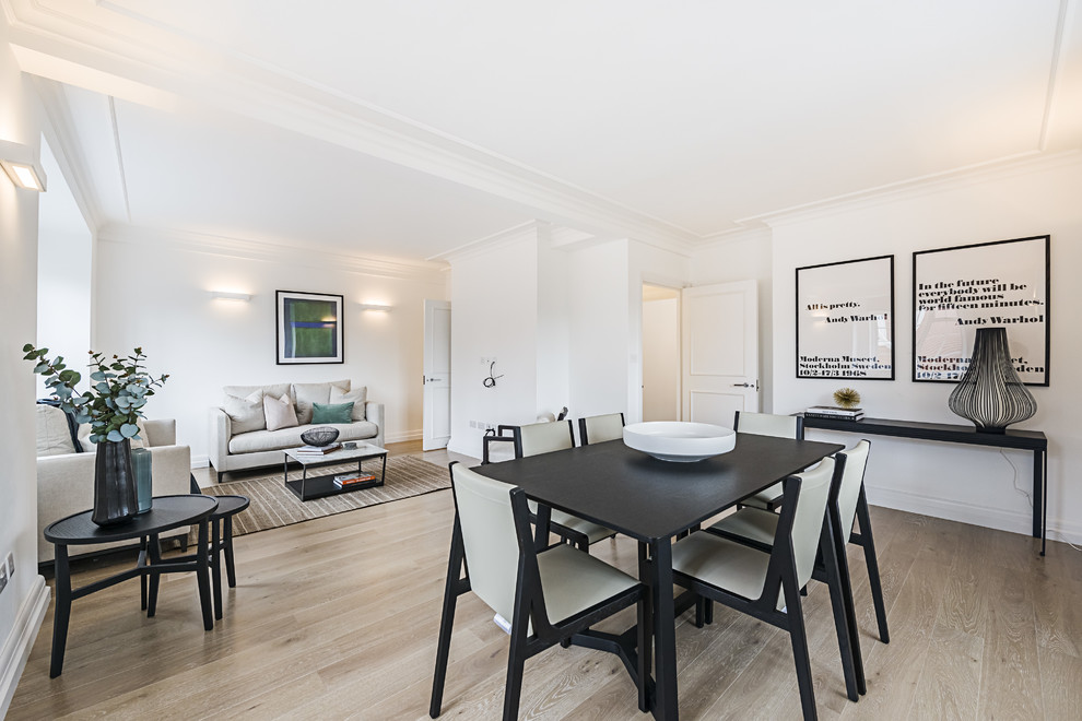 Photo of a medium sized modern dining room in London with white walls, light hardwood flooring and beige floors.