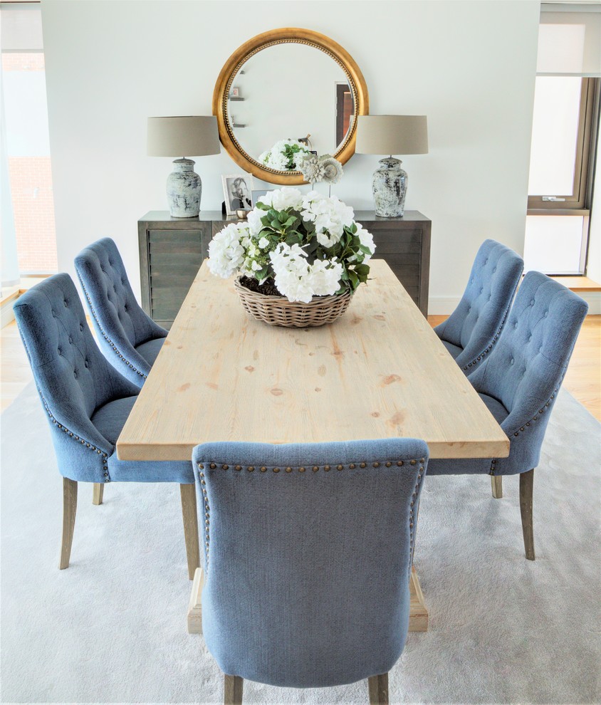 Cette photo montre une salle à manger ouverte sur le salon tendance de taille moyenne avec un mur blanc, parquet clair, aucune cheminée et un sol gris.