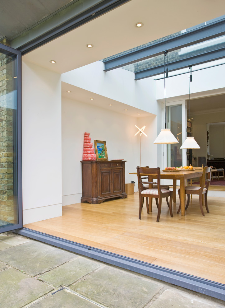 Moderne Wohnküche mit weißer Wandfarbe und hellem Holzboden in London
