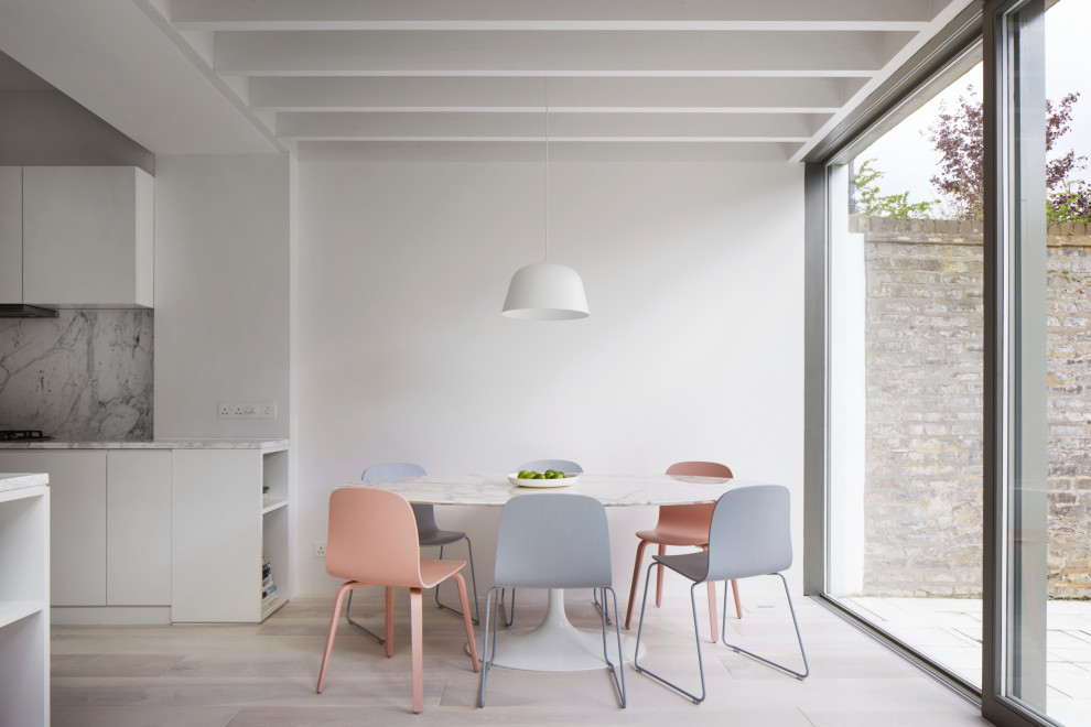 This is an example of a medium sized contemporary dining room in London with white walls, light hardwood flooring, beige floors and exposed beams.