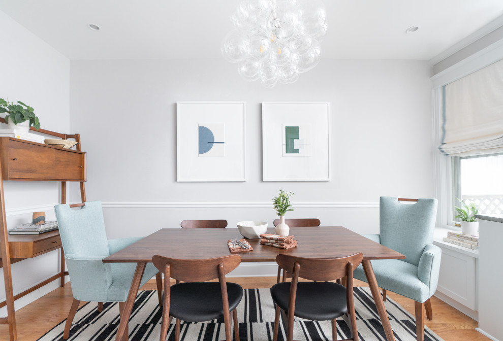 Photo of a scandi dining room in DC Metro with green walls, medium hardwood flooring and no fireplace.