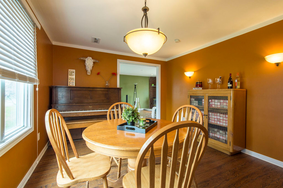 Inredning av ett klassiskt mellanstort kök med matplats, med orange väggar och laminatgolv