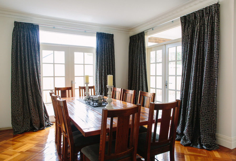Foto di un'ampia sala da pranzo aperta verso la cucina contemporanea con pareti bianche e parquet chiaro