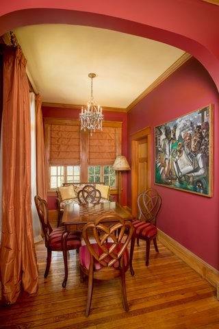 Exemple d'une salle à manger chic avec un mur rouge et parquet clair.