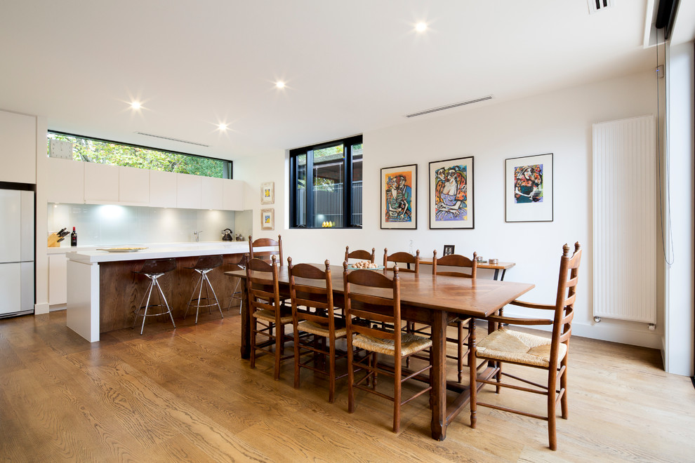 Diseño de comedor de cocina moderno de tamaño medio con paredes blancas y suelo de madera en tonos medios