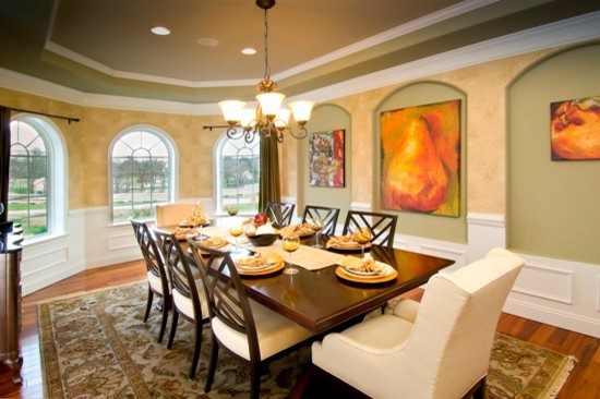 Esempio di una grande sala da pranzo aperta verso il soggiorno tradizionale con pareti verdi e pavimento in legno massello medio