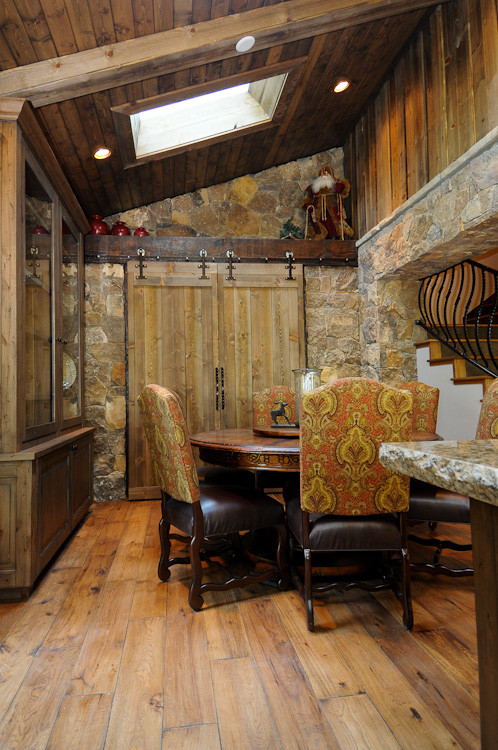 Immagine di una sala da pranzo aperta verso la cucina stile rurale di medie dimensioni con pareti marroni e pavimento in legno massello medio