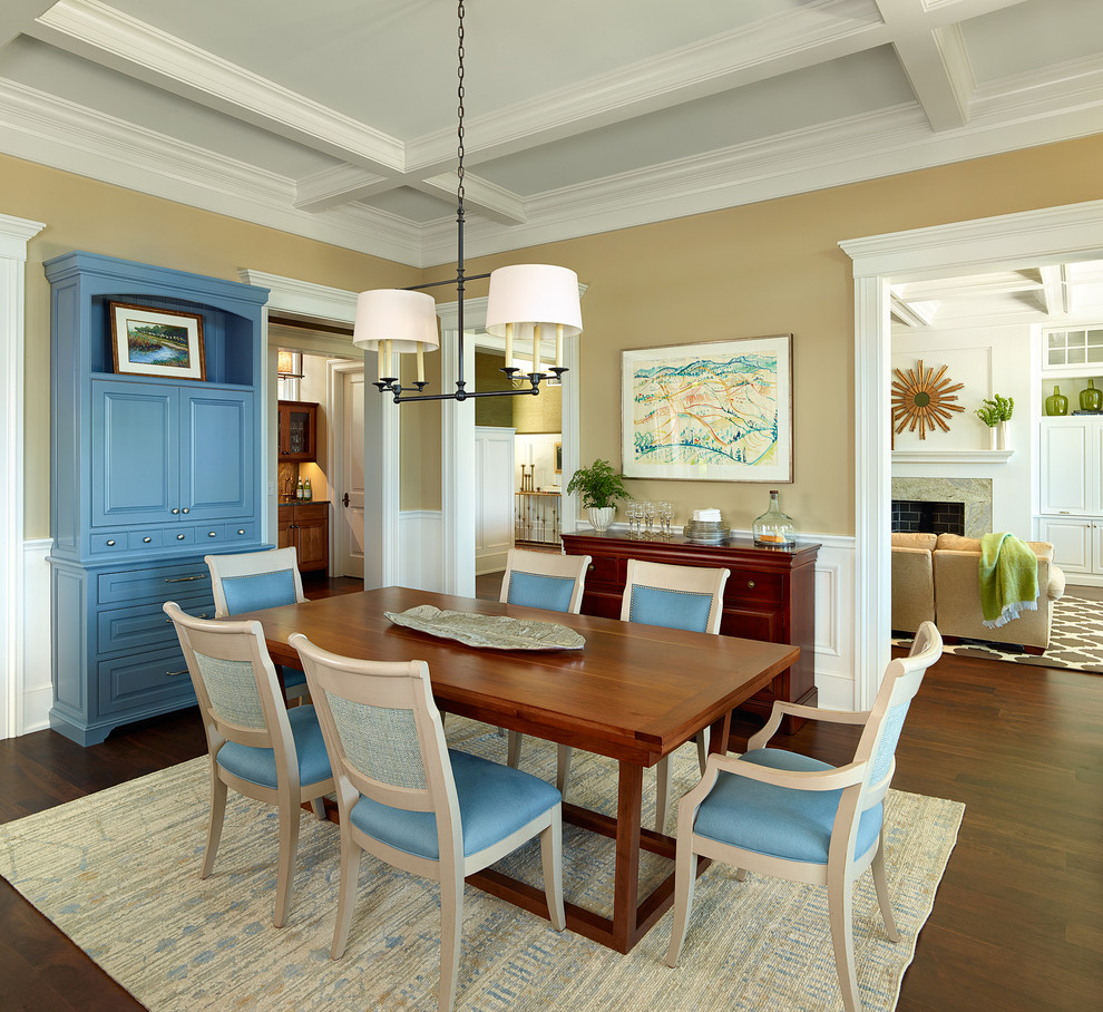 Immagine di una sala da pranzo aperta verso la cucina classica con pareti beige e parquet scuro