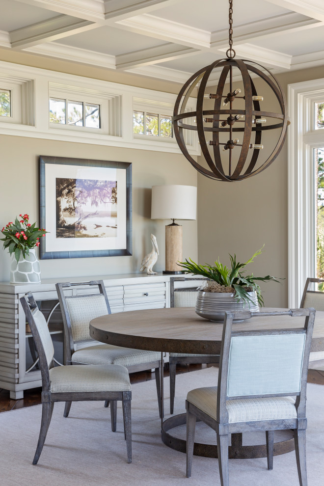 Example of a beach style dark wood floor, brown floor and coffered ceiling dining room design in Charleston with beige walls