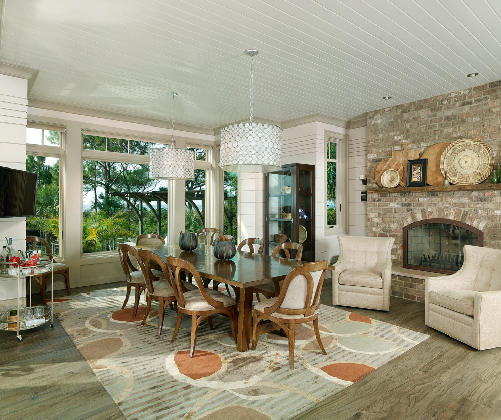 Cette image montre une salle à manger ouverte sur le salon marine avec un mur blanc, un sol en bois brun, une cheminée standard, un manteau de cheminée en brique et un plafond en lambris de bois.