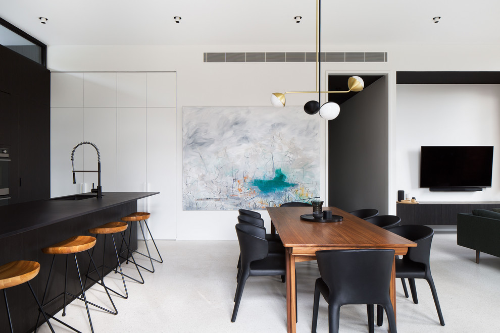 Esempio di una sala da pranzo design con pareti bianche, pavimento in cemento e pavimento grigio