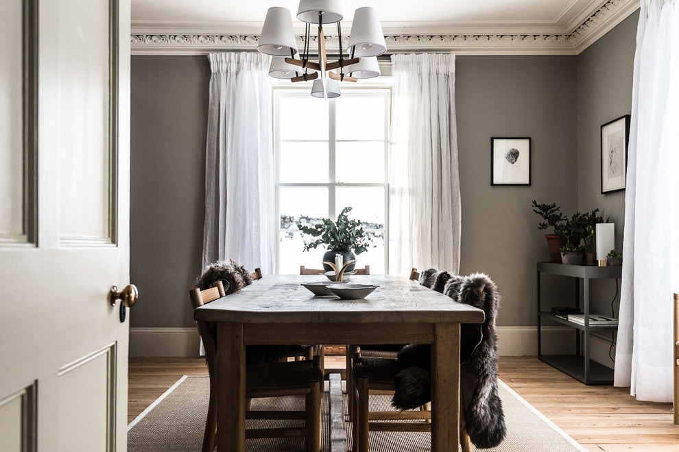 This is an example of a medium sized dining room in Edinburgh with grey walls and medium hardwood flooring.