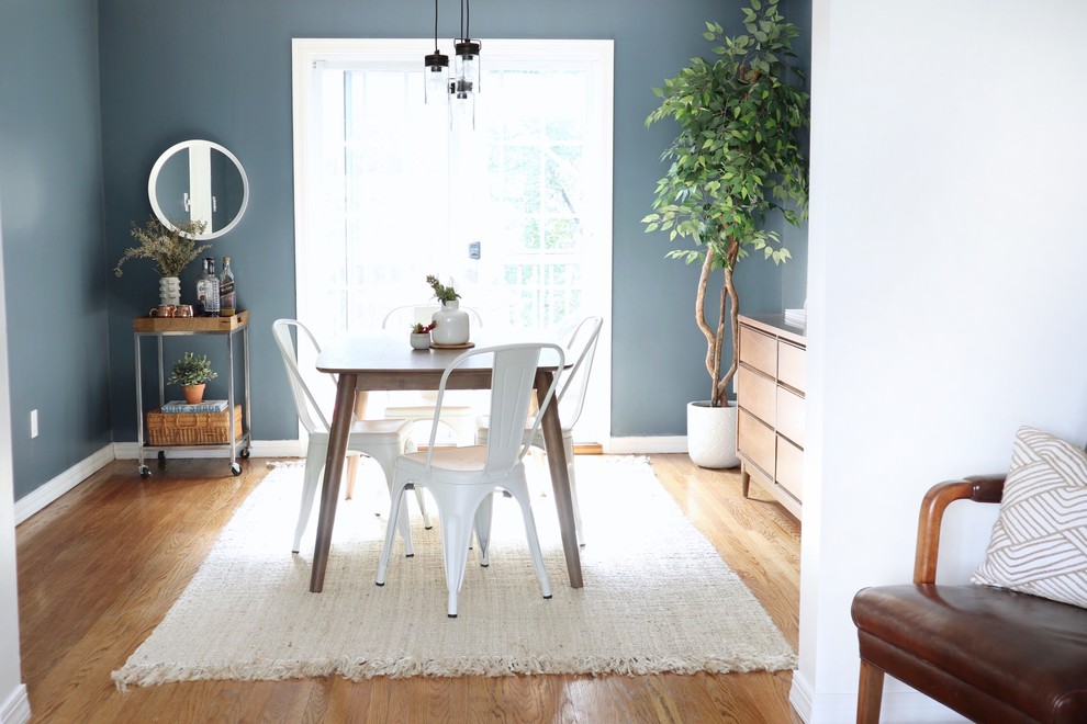 Inspiration pour une salle à manger vintage fermée et de taille moyenne avec un mur bleu et un sol en bois brun.