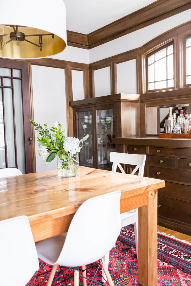 Foto di una sala da pranzo aperta verso la cucina moderna di medie dimensioni con pareti bianche, parquet chiaro, nessun camino e pavimento marrone