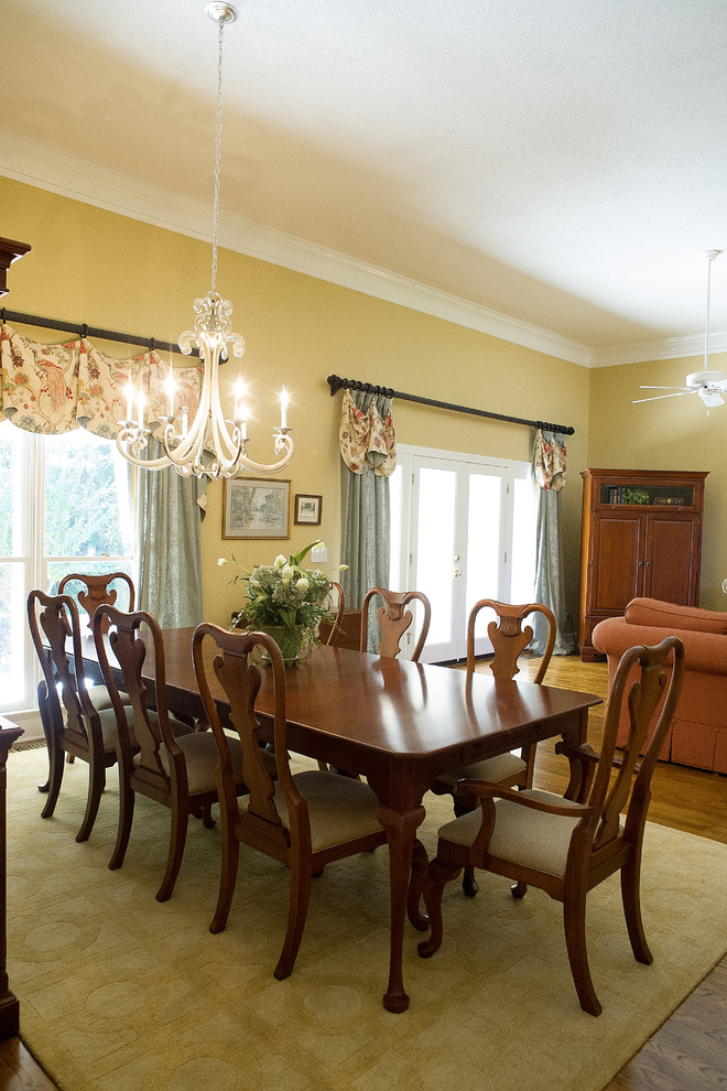This is an example of a large classic kitchen/dining room in Atlanta with yellow walls, dark hardwood flooring and no fireplace.