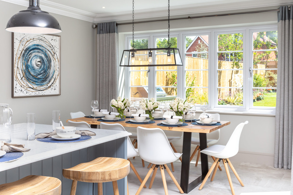Exemple d'une salle à manger ouverte sur la cuisine nature de taille moyenne avec un mur gris et un sol gris.