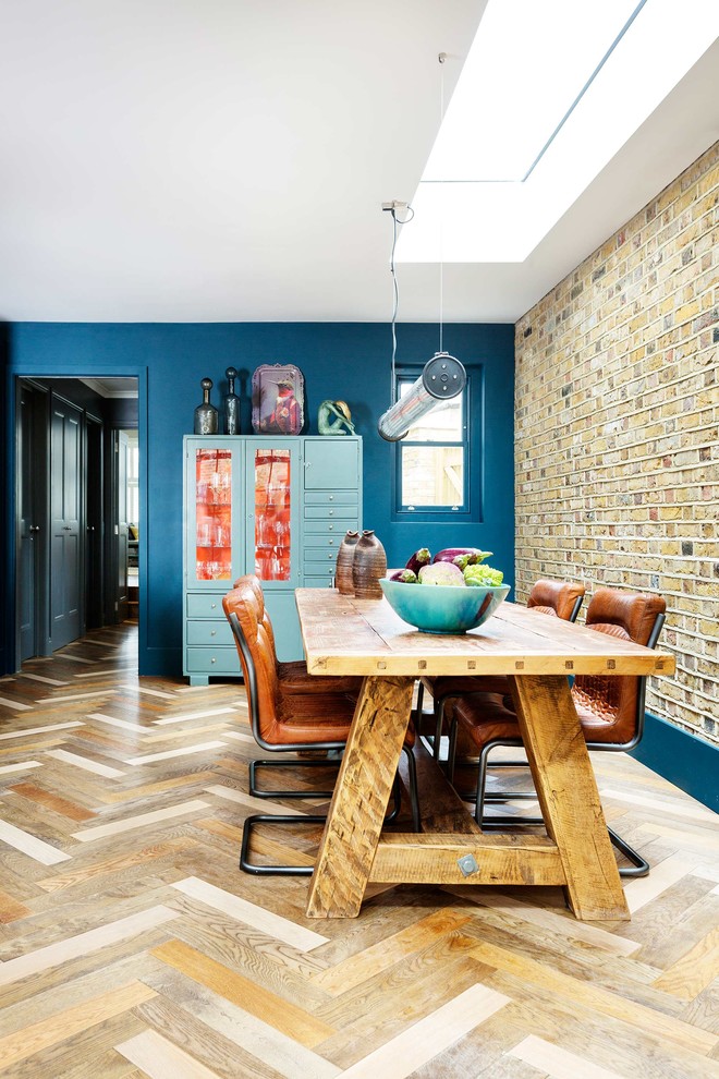 Idée de décoration pour une salle à manger tradition avec un mur bleu, un sol en bois brun et un sol beige.