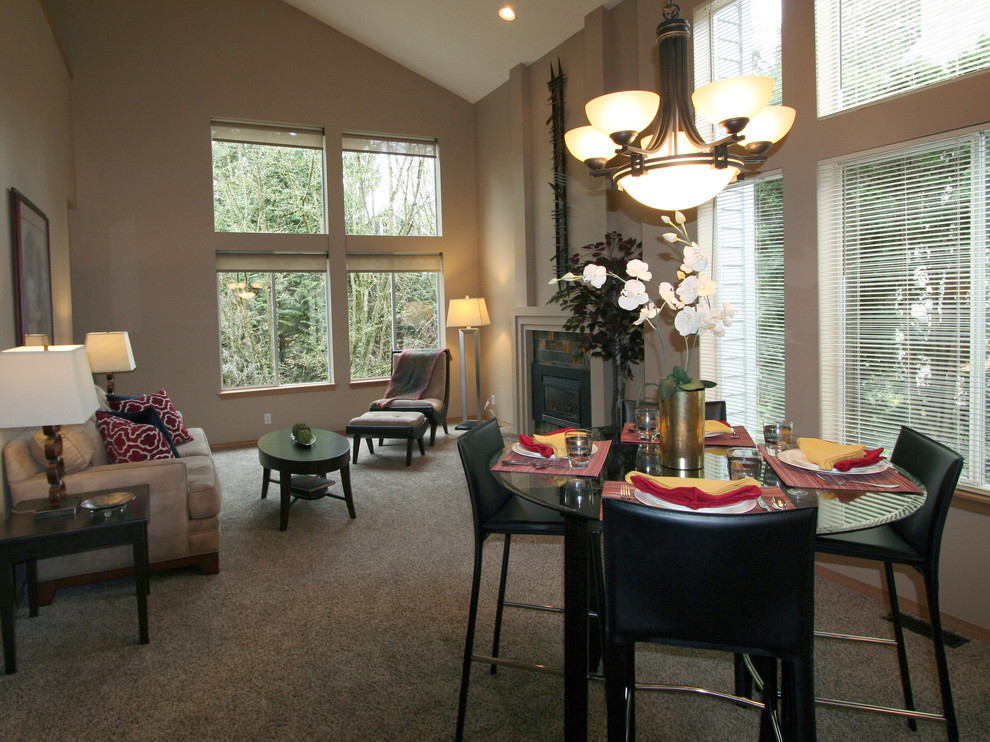 Photo of a contemporary dining room in Seattle with beige walls, carpet and a standard fireplace.