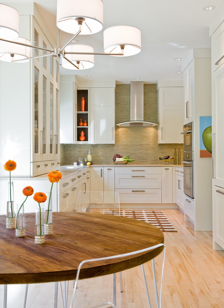 Aménagement d'une salle à manger ouverte sur la cuisine moderne avec un mur blanc, parquet clair et aucune cheminée.