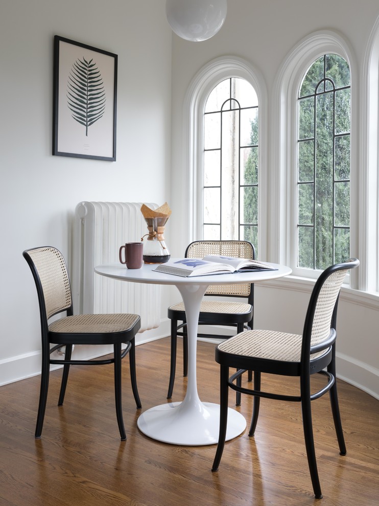 Immagine di una sala da pranzo classica con pareti bianche e parquet chiaro