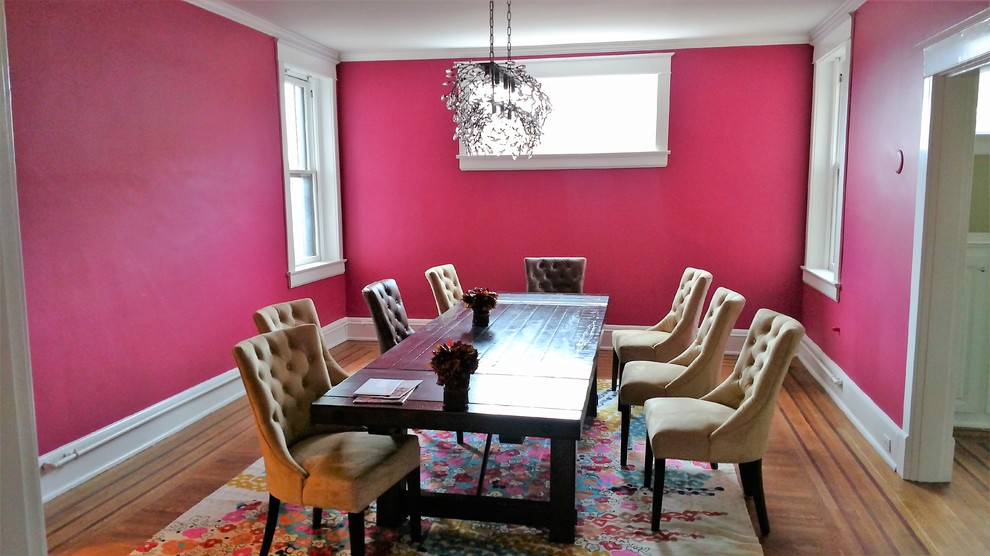 Eklektisk inredning av en stor separat matplats, med rosa väggar och mörkt trägolv